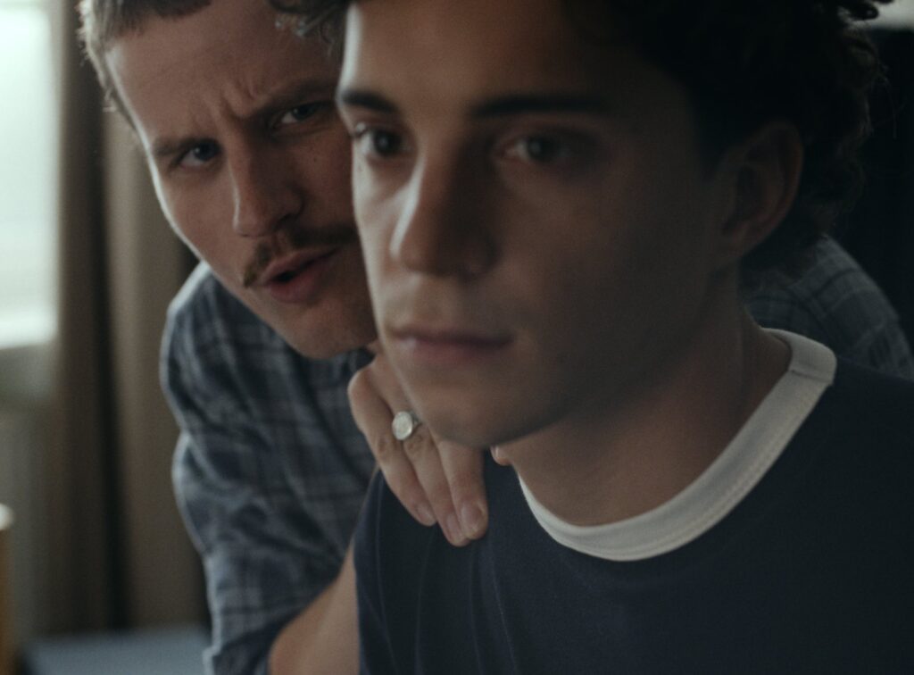 De gymbro fluistert in het oor van een jongen, still uit de UNICEF-film Turn Down the Noise